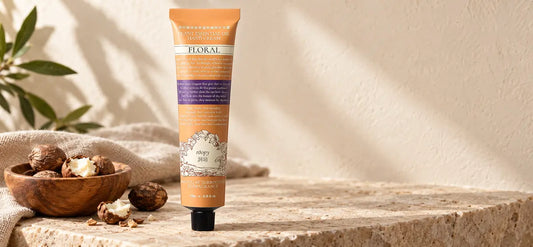 ROOPY hand cream beside shea nuts on a warm stone surface